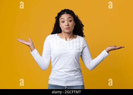 Wer Weiß. Zweifelhafte Afroamerikanische Frau, Die Schultern Zuckerte Und Arme Streckte, Porträt Von Unsicher Zögerlicher Schwarzer Millennial-Frau, Die Isolat Stehend Stockfoto