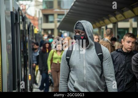 Manchester, Großbritannien. August 2021. Ein Mann, der eine Maske als vorbeugende Maßnahme gegen die Verbreitung von covid-19 trägt, wartet darauf, in eine Straßenbahn zu steigen.Masken sind für den öffentlichen Nahverkehr im Großraum Manchester immer noch obligatorisch, da Maskengesetze jetzt in die Satzung der TFGM aufgenommen wurden. Transport for Greater Manchester (TFGM) drohte mit einer Geldstrafe von 200 Pfund für jeden, der ohne Maske gefangen wurde (Foto von Ryan Jenkinson/SOPA Images/Sipa USA) Quelle: SIPA USA/Alamy Live News Stockfoto