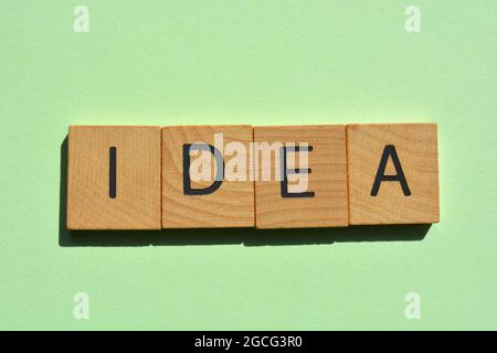 Idee, Wort in Holzalphabetbuchstaben isoliert auf grünem Hintergrund als Banner-Überschrift Stockfoto