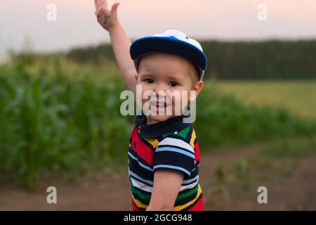 Ein kleiner Junge macht Gesichter und spielt in einem Kornfeld Stockfoto