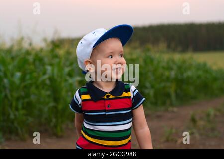 Ein kleiner Junge macht Gesichter und spielt in einem Kornfeld Stockfoto