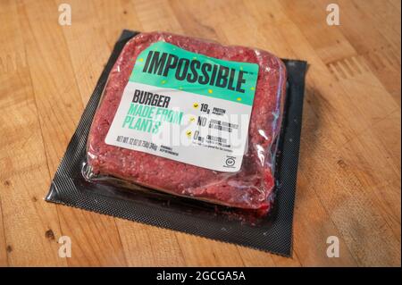 Packung mit veganem Fleisch, Markenname Impossible Burger auf einem Holzbrett Stockfoto