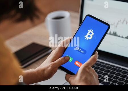 Junge Trader Frau mit Börse Krypto Währung App mit Handy im Home Office - Aktienmarkt Investor - Fokus auf Smartphone-Bildschirm Stockfoto