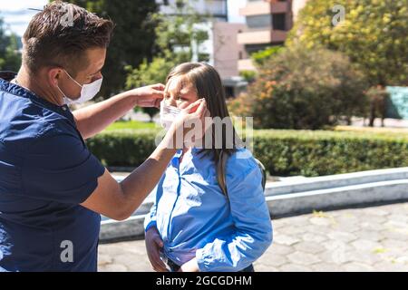 Vater, der seine Tochter am Eingang des Unterrichts mit der Maske behielt. Zurück zur Schule Stockfoto