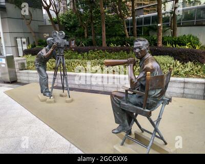 Eine Statue eines Kameramannes und legendären Regisseurs, die auf einem Regiestuhl in der Avenue of Stars in Hongkong sitzt. Stockfoto