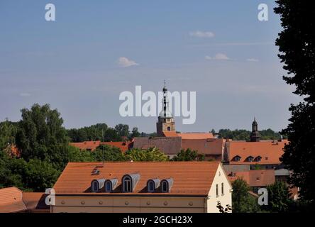 26. Juli 2021, Brandenburg, Bad Belzig: Blick vom Schloss Eisenhardt auf die Häuser in der Innenstadt und den Turm der Marienkirche. Die romanische Hallenkirche wurde in der zweiten Hälfte des 13. Jahrhunderts erbaut und beherbergt heute das Brandenburgische Orgelmuseum. Die gut erhaltene Schlossanlage am Stadtrand ist ein Wahrzeichen der Stadt, das von weitem zu sehen ist. Die Burg wurde 997 erstmals von Kaiser Otto III. In einem Dokument als Burgwardium belizi erwähnt und vermutlich hundert Jahre zuvor von einem Elbslawer Stamm gegründet. Der Name war Ausdruck des Wunsches, dass das Schloss sein sollte Stockfoto