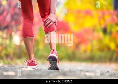 Sportverletzung Läuferin Frau mit Schmerzen, die während des Traillaufes im Freien den Beinkälbermuskel zurückhält, der durch Krämpfe verletzt wird. Unfall mit Laufmuskeln. Stockfoto