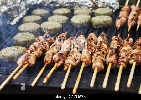 BBQ Burger, gegrillte Herzen auf Spieße und Rauch Grillparty. Nahaufnahme. Stockfoto