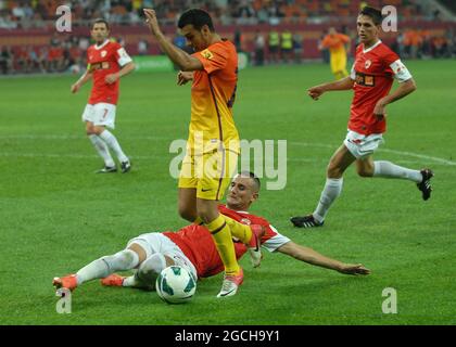 BUKAREST, RUMÄNIEN - 11. AUGUST 2012: Dragos Grigore von Dinamo lässt sich während des Vorsaison-Freundschaftsspiels zwischen Dinamo Bucuresti und dem FC Barcelona in der National Arena gegen Sergio Busquets aus Barcelona angehen. Stockfoto