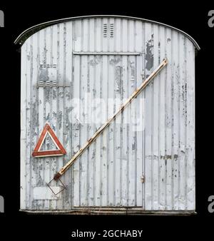 Der alte Metallanhänger der Straßenarbeiter wurde mit weißer Farbe gestrichen. Isoliert auf Schwarz Stockfoto