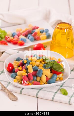 Farbige Gnocchi mit Gemüse und süßem Mais. Stockfoto