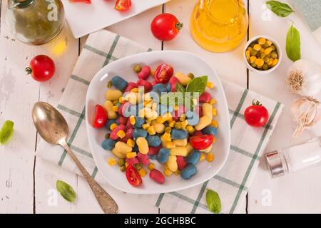 Farbige Gnocchi mit Gemüse und süßem Mais. Stockfoto