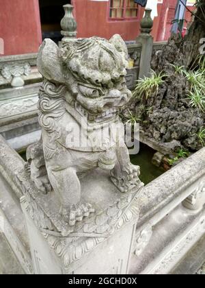 Eine steinerne Statue eines Löwenhundes auf einem Zaunposten am Hui Guang Tempel im alten Bezirk Lizhuang Stockfoto