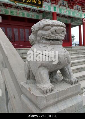 Eine steinerne Löwenhund-Schutzstatue auf einem Treppengeländer an einer nachgebauten Pagode im Nanxi Bezirk der Stadt Yibin Stockfoto