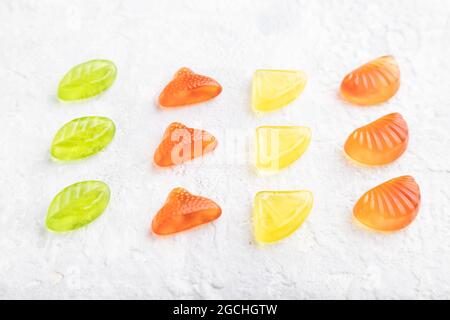 Verschiedene Fruchtgelee-Bonbons auf grauem Beton-Hintergrund. Seitenansicht, Nahaufnahme. Stockfoto