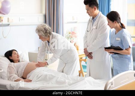 Arzt, der eine Schwangerin auf der Krankenhausstation untersucht Stockfoto