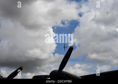 Ein Ausstellungsflugzeug, das zwischen den Propellern eines Lancaster Bombers fliegt Stockfoto