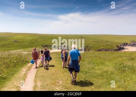 Urlauber, die einen Weg hinauf- und hinunterlaufen, der zum abgelegenen Polly Joke Porth-Witz in Newquay in Cornwall führt. Stockfoto