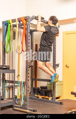 Athlet Mann tun Pull-ups Übung mit Bar im Fitnessstudio Stockfoto