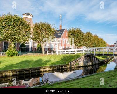 Häuser mit Gärten am Wasser am Kanal Eegracht in der Stadt IJlst, Friesland, Niederlande Stockfoto