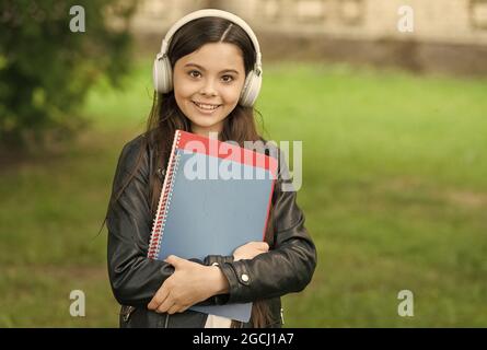 Mädchen hören Audio tragen Lehrbücher auf dem Weg zur Schule, Schulclub Konzept Stockfoto