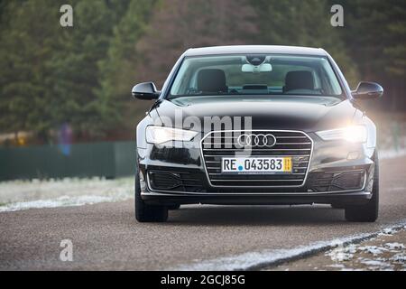GRODNO, WEISSRUSSLAND - DEZEMBER 2019: Audi A6 4G, C7 2016 schwarz metallic Frontlicht auf Outdoor auf Winter leere Straße mit Waldhintergrund mit Stockfoto