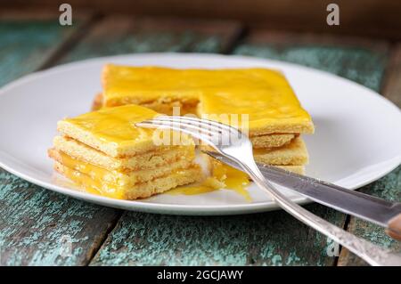 Hausgemachter, unperfekter Zitronenkuchen auf weißem Teller aus der Nähe Stockfoto