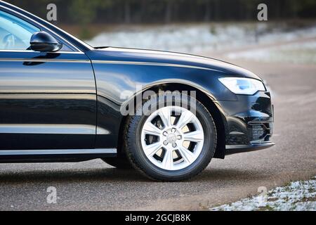 GRODNO, WEISSRUSSLAND - DEZEMBER 2019: Audi A6 4G C7 Luxuswagen Nahaufnahme rechte Seitenansicht Vorderradteil mit Leichtmetallfelge mit Dunlop Winterreifen mit Stockfoto