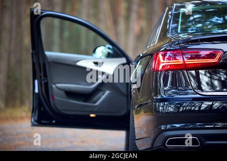GRODNO, WEISSRUSSLAND - DEZEMBER 2019: Audi A6 4G, C7 2016 Rücklicht eines schwarz-metallischen Autos auf der linken Seite, Nahaufnahme mit geöffneter Tür, außer Fokus auf Wald Stockfoto