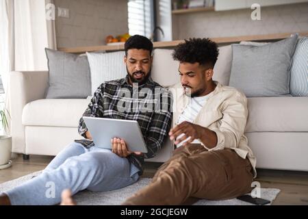 Junge Studenten Brüder in Küche drinnen zu Hause, mit Tablet. Stockfoto