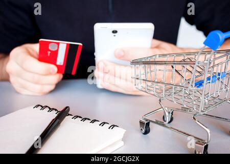 Man kauft online mit Smartphone und Bankkarte Stockfoto