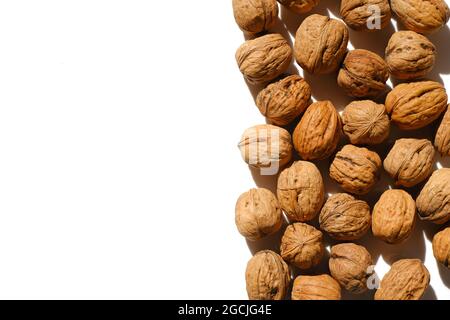 Nahaufnahme von ungeschälten Walnüssen auf hellem Hintergrund. Nüsse und Samen. Gesunde Fette. Stockfoto