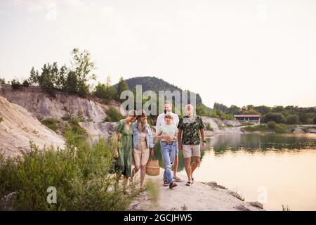 Glückliche Familie mit mehreren Generationen im Sommerurlaub, Wandern am See. Stockfoto