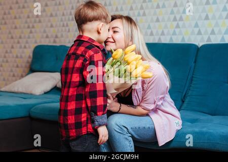 Ein kleiner Junge gibt seiner Mutter Blumen .mother's day Konzept Stockfoto