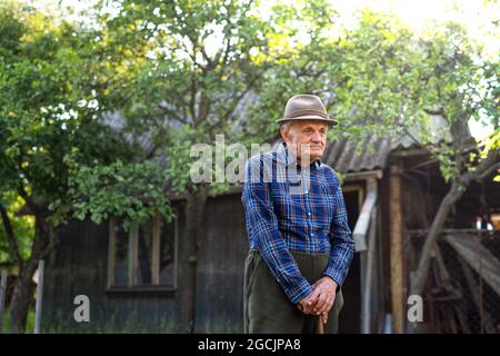 Porträt eines älteren Mannes, der im Garten steht und sich ausruht. Stockfoto