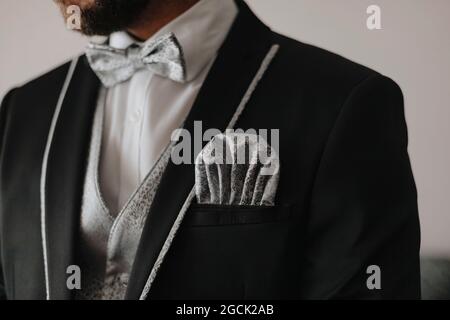 Crop anonymer bärtiger Bräutigam im stilvollen Hochzeits-Smoking mit Fliege und elegantem Taschentuch Stockfoto