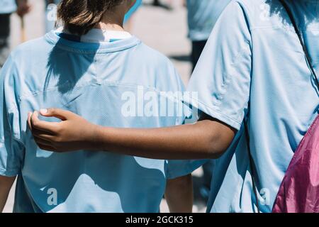Rückansicht der Ernte unkenntlich multirassische Teenager-Freunde in blauer Uniform, die an der Freiwilligenarbeit im Umweltschutz am Sommertag teilnehmen Stockfoto