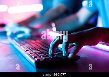 Konzentrieren Sie sich auf die Finger, Nahaufnahme von professionellen Online-Gamer-Händen, die während des Spiels im Turnier schnell auf die Tastatur treffen Stockfoto