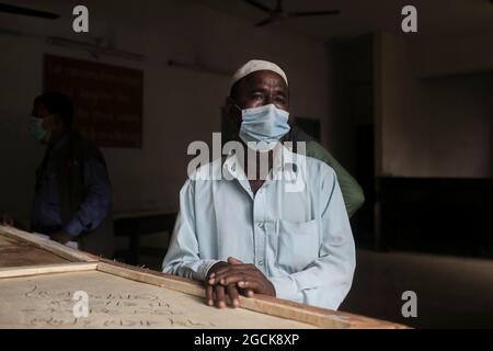 Non Exclusive: DHAKA, BANGLADESCH - AUGUST 7: Ein Mann weint, während er den Sarg mit den Überresten seiner Verwandten hält, die bei dem tödlichen Feuer, das sie getötet hatten, gestorben sind Stockfoto