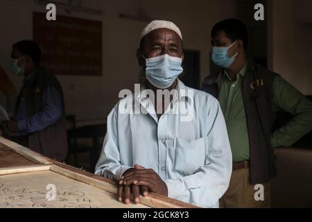 Non Exclusive: DHAKA, BANGLADESCH - AUGUST 7: Ein Mann weint, während er den Sarg mit den Überresten seiner Verwandten hält, die bei dem tödlichen Feuer, das sie getötet hatten, gestorben sind Stockfoto