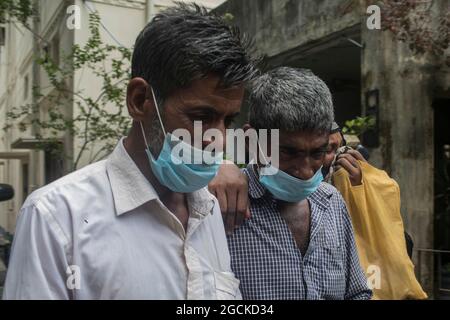 Dhaka, Bangladesch, 7. August: Ein Mann weint, während er den Sarg mit den Überresten seiner Verwandten hält, die bei dem tödlichen Feuer, das im vergangenen Monat eine Narayanganj-Fabrik verschlungen hatte, gestorben sind. Die Behörden haben die 21 Leichen der Arbeiter übergeben, die am vergangenen 8. Juli beim Fabrikfeuer von Hashem Foods Ltd in Rupganj in Narayanganj ums Leben kamen. Die verkohlten Leichen wurden von 12:00 bis 13:00 Uhr freigelassen, nachdem die forensische Einheit der Kriminalpolizei (CID) 45 von 48 verstorbenen Beschäftigten durch DNA-Analysen identifiziert hatte. Allerdings muss CID noch die Identität von drei weiteren Organen bestätigen. Kredit: S Stockfoto