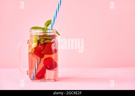 Erdbeere selbstgemachte Limonade in einem Einmachglas mit Kopierraum auf rosa Hintergrund. Kalt erfrischender Cocktail, Party, Sommerkonzept Stockfoto