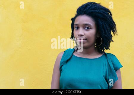 Porträt einer jungen schwarzen Frau mit afro-Frisur an einer Wand gelehnt Stockfoto
