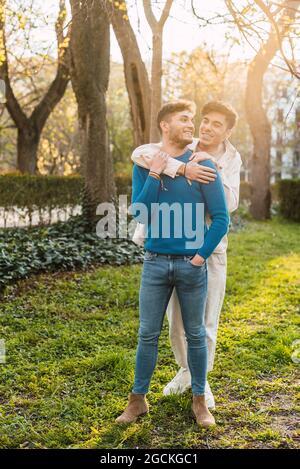 Fröhliche LBGT-Männer umarmen sich, während sie im Park stehen und einander angusten Stockfoto