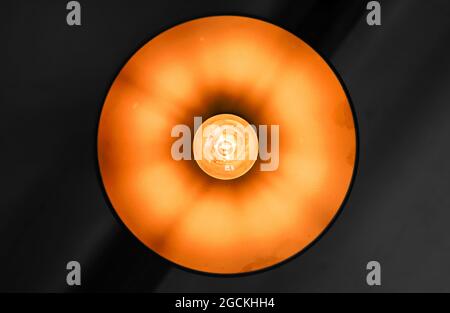 Vintage stilisierte Kronleuchter mit Wolfram-Lampe in einem glänzenden runden Lampenschirm montiert, Nahaufnahme frontale Ansicht Stockfoto