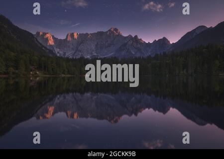 Herrliche Landschaft von ruhigen Teich umgeben von Bergen unter Sonnenuntergang Himmel in Slowenien Stockfoto