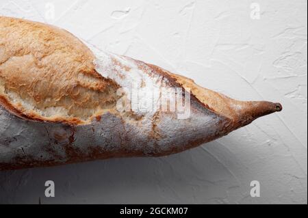 Appetitlich frisch gebackenes Baguette mit knuspriger Kruste auf weißem Tisch Stockfoto
