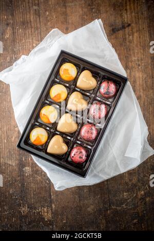 Draufsicht auf süße bunte Schokolade Bonbons in Box auf Holztisch platziert Stockfoto
