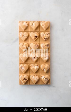 Draufsicht auf köstliche Süßigkeiten mit Nüssen in Herzform auf Marmortisch Hintergrund Stockfoto