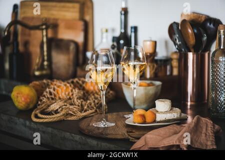 Orangen- oder Amberwein in Gläsern über der Küchentheke Stockfoto